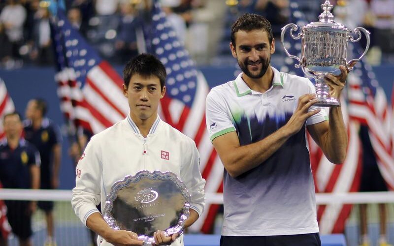 Cilic of Croatia and Nishikori of Japan hold their trophies after Cilic won their men's singles final match at the 2014 U.S. Open tennis tournament in New York