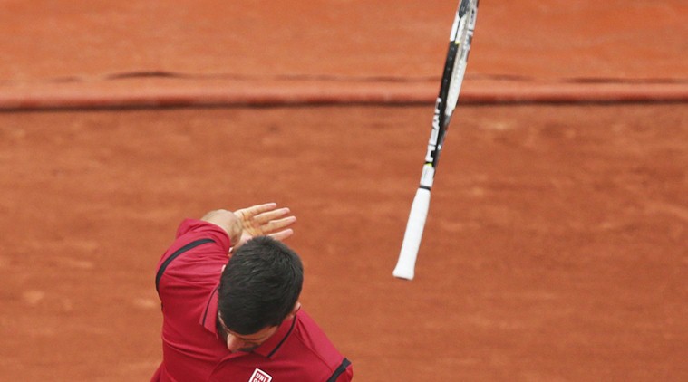 Serbia's Novak Djokovic throws his racket away after missing a return in the fourth round match of the French Open tennis tournament against Tomas Berdych of the Czech Republic at the Roland Garros stadium in Paris, France, Thursday, June 2, 2016. (AP Photo/David Vincent)