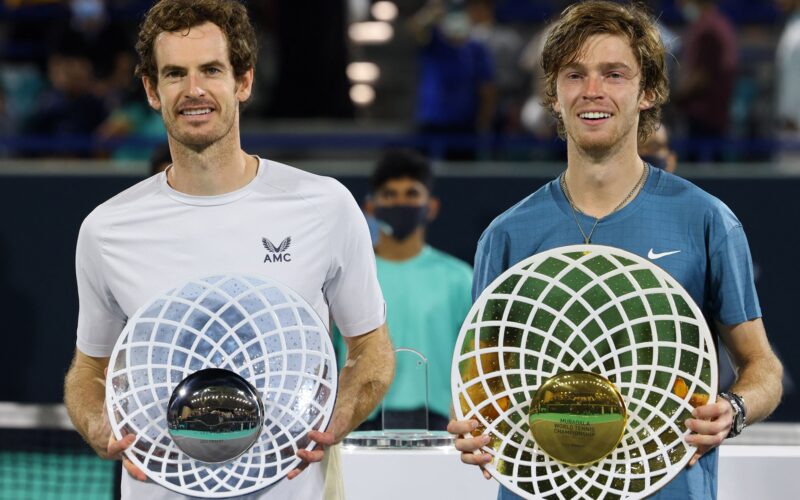 (R to L) First-place winner Andrey Rublev of Russia holds up his trophy alongside second-place winner Andy Murray of Britain during the awards ceremony after the final match of the Mubadala World Tennis Championship in the Gulf emirate of Abu Dhabi on December 18, 2021. (Photo by Giuseppe CACACE / AFP)